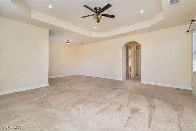 10188 Mimosa Silk Dr, Fort Myers, FL 33913 - spare room featuring ceiling fan, light colored carpet, arched walkways, a tray ceiling, and visible vents