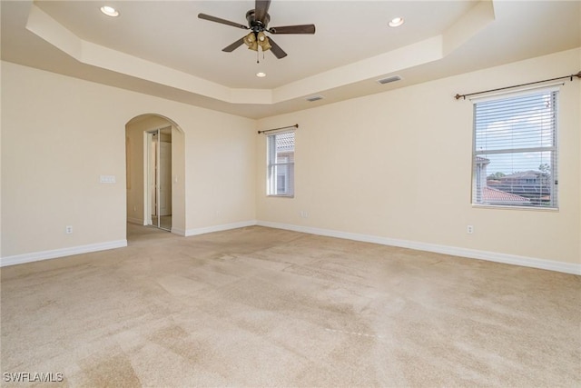 10188 Mimosa Silk Dr, Fort Myers, FL 33913 - empty room with arched walkways, a tray ceiling, visible vents, and light carpet