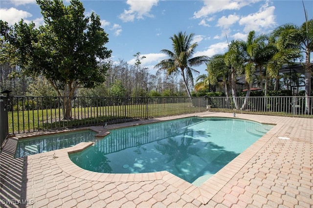 view of pool with fence and a pool with connected hot tub