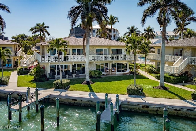 back of house featuring a water view, a yard, and a patio area