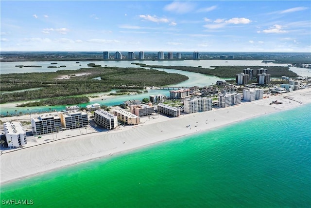 birds eye view of property with a water view and a beach view