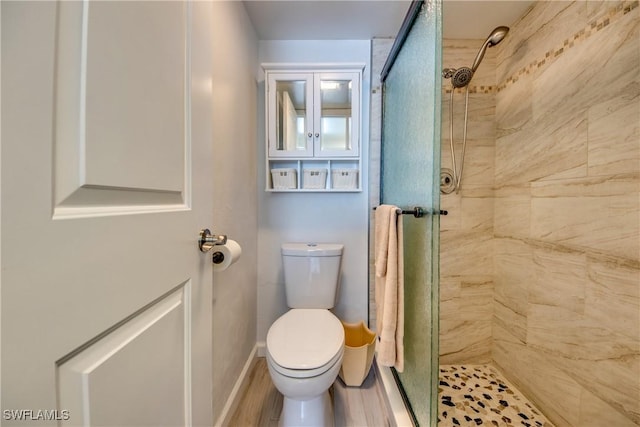 full bathroom with baseboards, a stall shower, and toilet