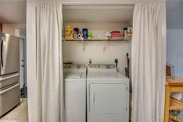 clothes washing area with washing machine and dryer and light tile patterned flooring