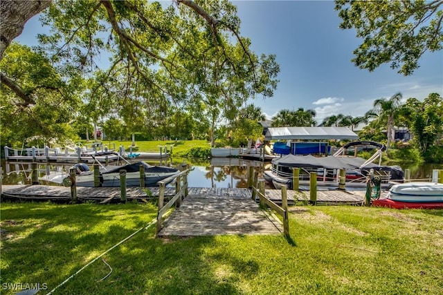 dock area featuring a water view and a lawn