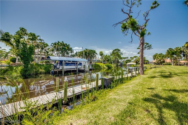 dock area with a lawn, a water view, and boat lift