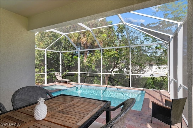 view of pool featuring a hot tub, a lanai, and a patio area