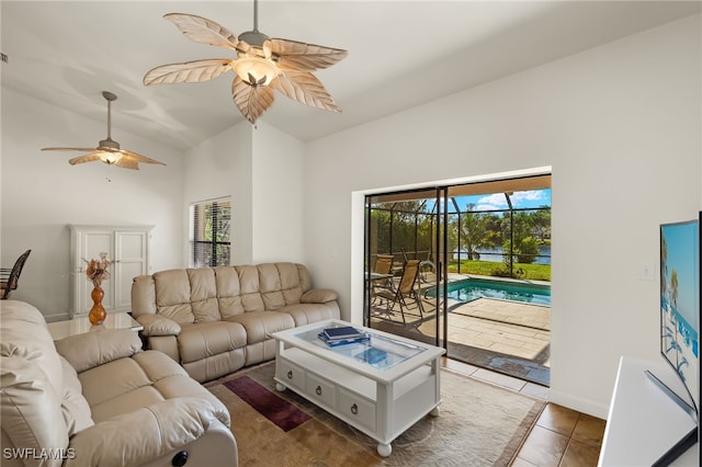 living room with dark tile patterned floors, lofted ceiling, and ceiling fan