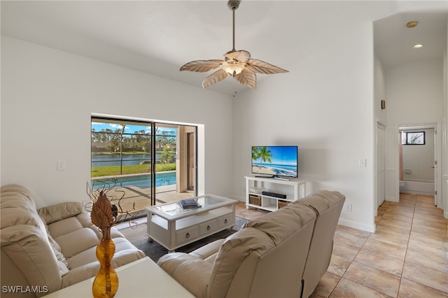 tiled living room featuring ceiling fan and high vaulted ceiling