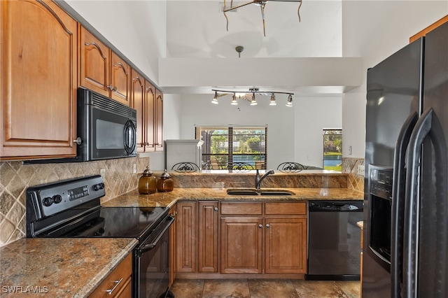 kitchen featuring stone counters, backsplash, sink, and black appliances