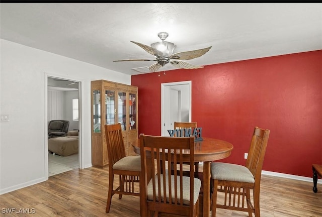 dining space with ceiling fan and light hardwood / wood-style floors