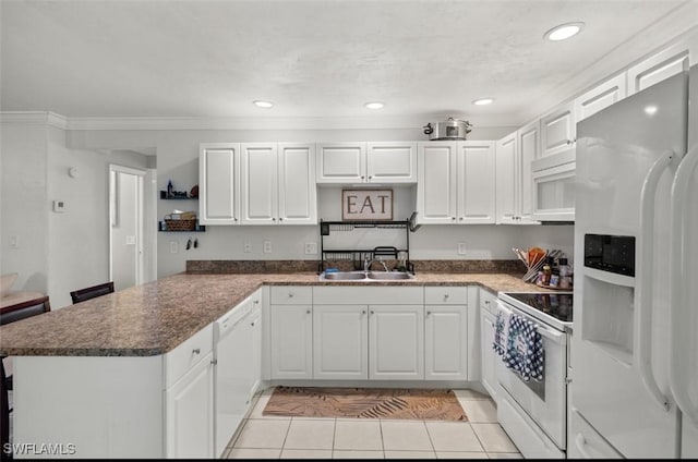 kitchen featuring white cabinets, white appliances, and kitchen peninsula