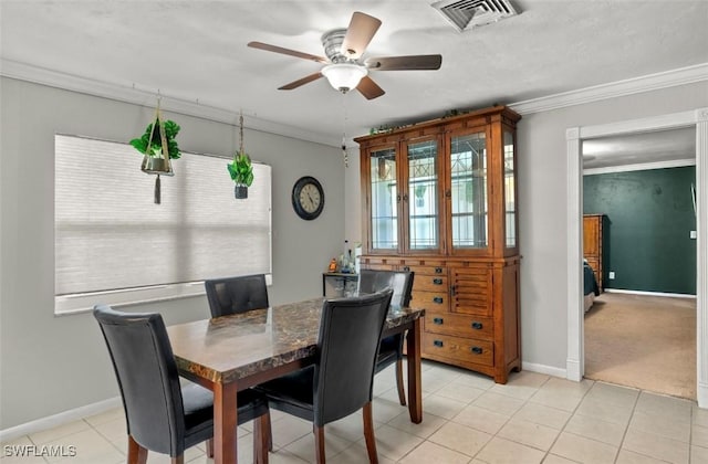 tiled dining room with crown molding and ceiling fan