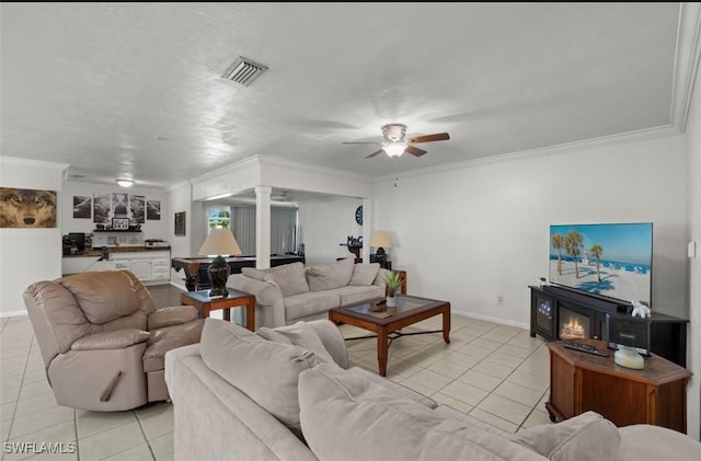 living room featuring light tile patterned floors, ornamental molding, and ceiling fan