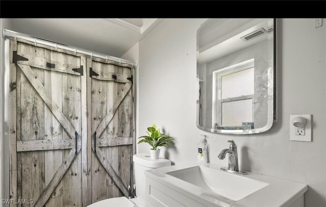 bathroom featuring a shower with curtain, vanity, and toilet