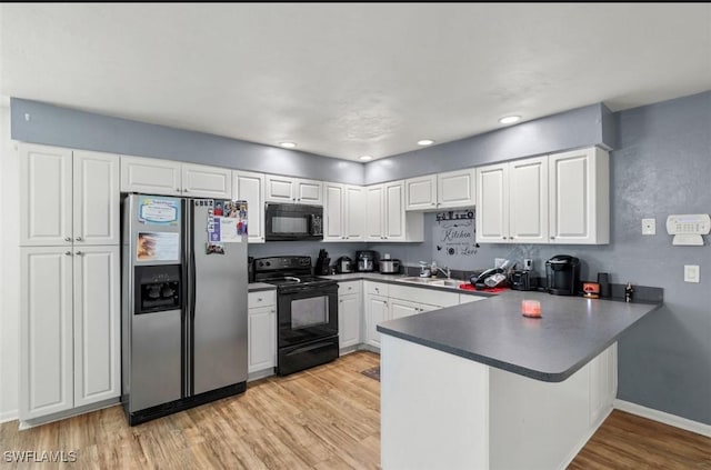 kitchen featuring sink, black appliances, kitchen peninsula, light hardwood / wood-style floors, and white cabinets