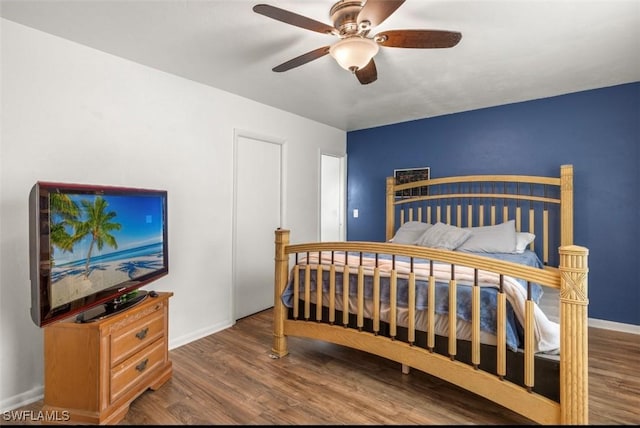 bedroom with dark hardwood / wood-style flooring and ceiling fan