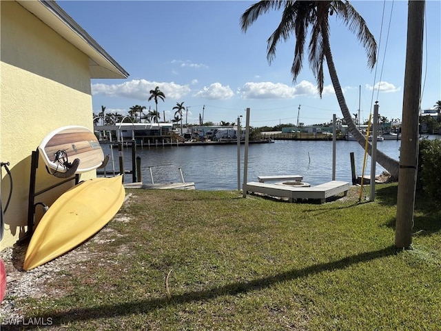 dock area with a lawn and a water view