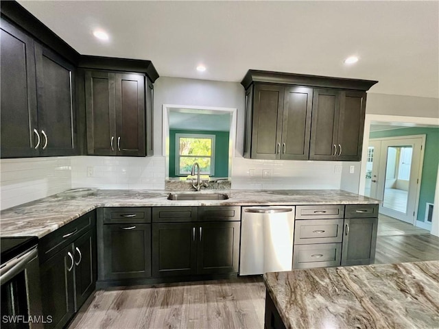 kitchen featuring sink, decorative backsplash, light wood-type flooring, and appliances with stainless steel finishes