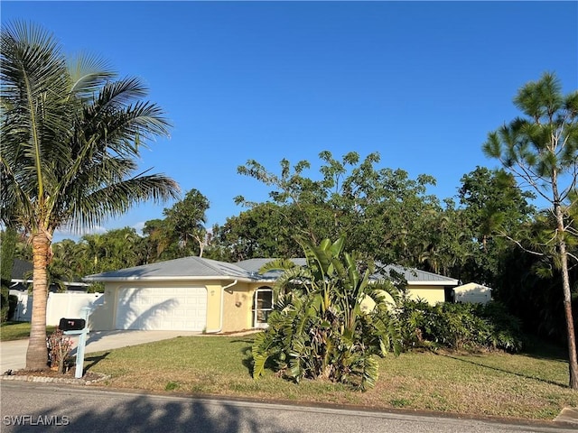 single story home with a garage and a front lawn