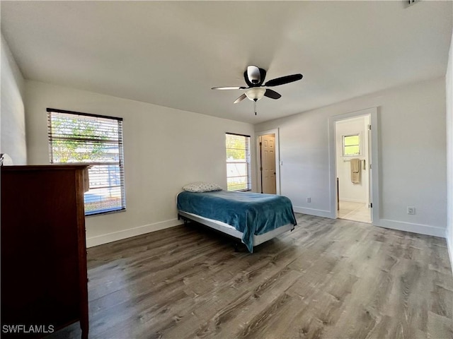 unfurnished bedroom with ceiling fan, wood-type flooring, and ensuite bathroom