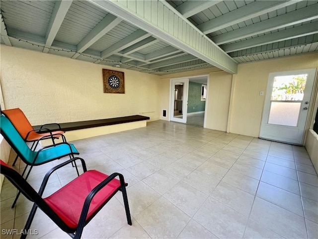 interior space featuring light tile patterned floors and beamed ceiling