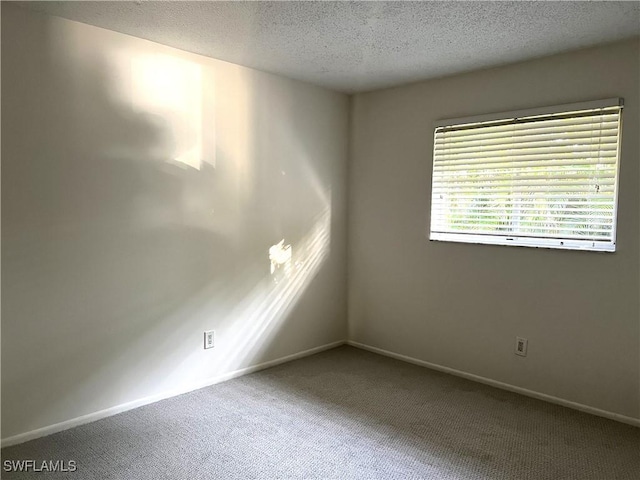 carpeted spare room with a textured ceiling