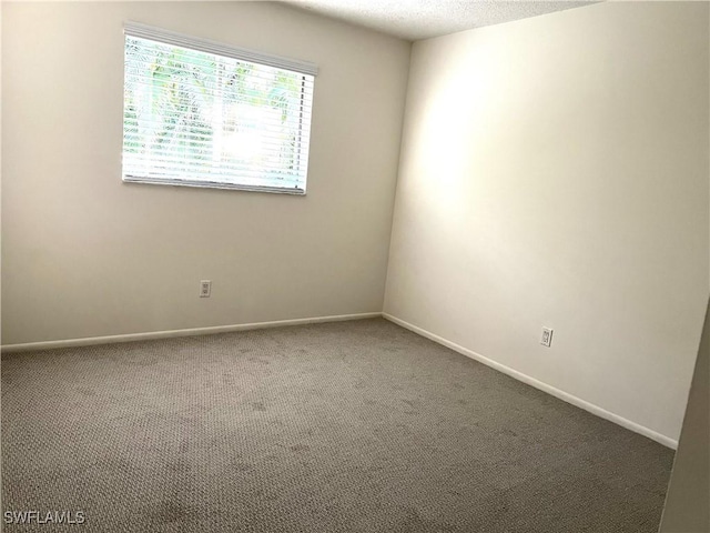 carpeted spare room featuring a textured ceiling