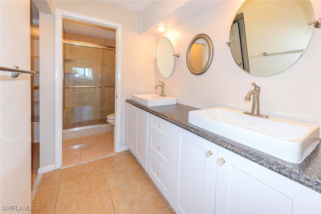 bathroom with an enclosed shower, tile patterned flooring, vanity, and toilet