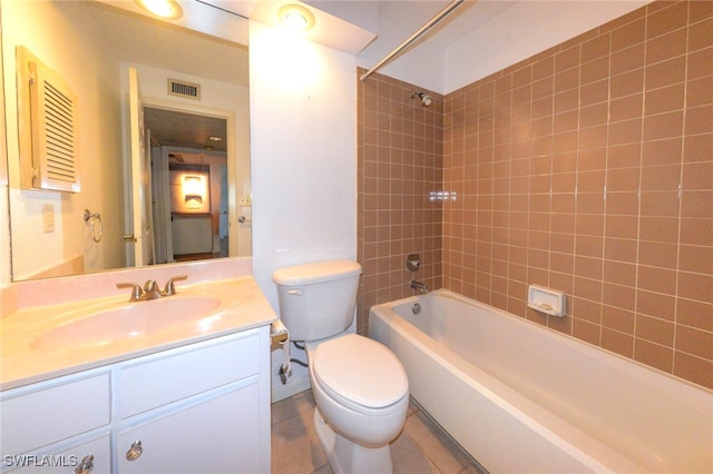 full bathroom featuring tile patterned flooring, vanity, tiled shower / bath, and toilet