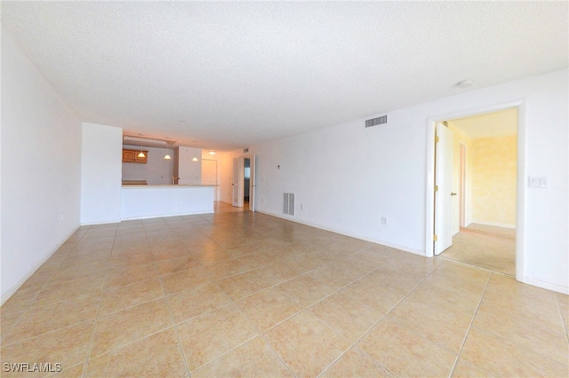 unfurnished living room with light tile patterned floors and a textured ceiling