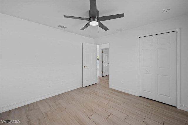 unfurnished bedroom featuring ceiling fan, a closet, and light wood-type flooring