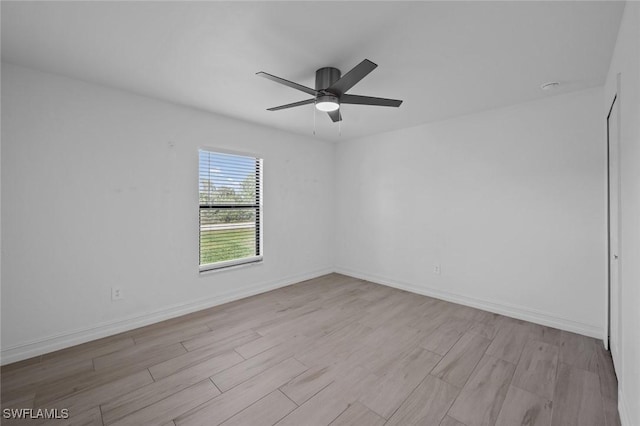 empty room with ceiling fan and light hardwood / wood-style flooring