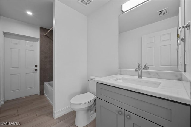 full bathroom with vanity, toilet, shower / washtub combination, and hardwood / wood-style floors