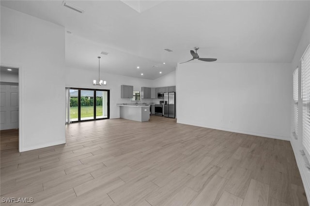 unfurnished living room featuring high vaulted ceiling, ceiling fan with notable chandelier, and light hardwood / wood-style flooring