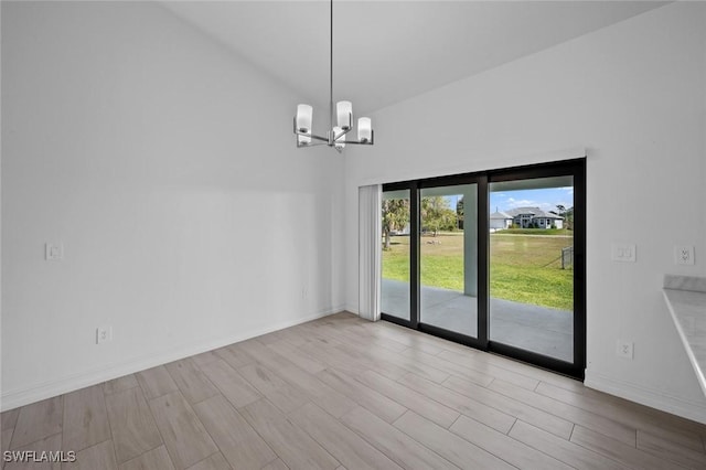 spare room with a notable chandelier and light hardwood / wood-style flooring