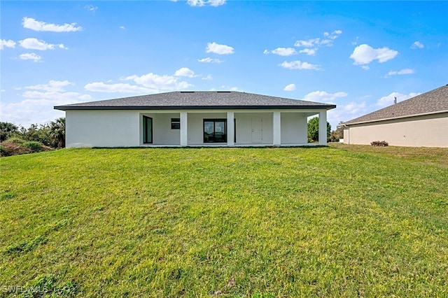 back of property featuring a lawn