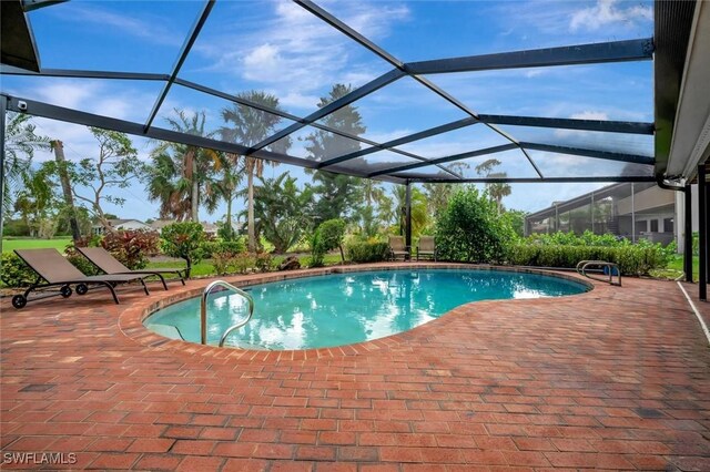 view of swimming pool featuring a patio area and glass enclosure