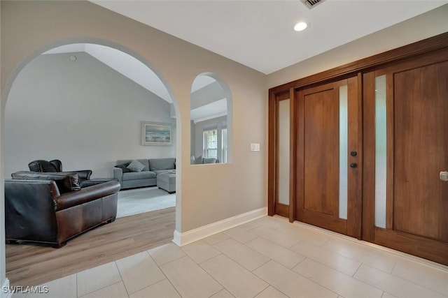 entrance foyer with vaulted ceiling and light tile patterned floors