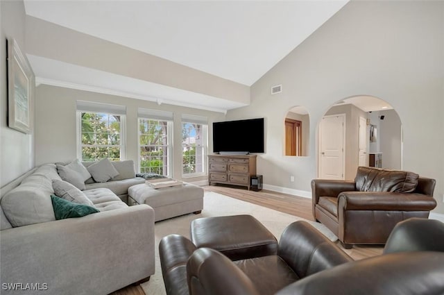 living room with high vaulted ceiling and light wood-type flooring