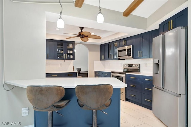 kitchen featuring a breakfast bar area, stainless steel appliances, kitchen peninsula, and blue cabinets