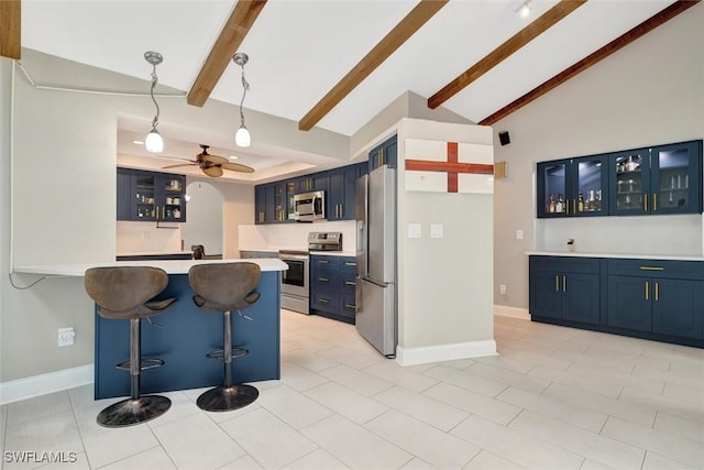 kitchen featuring blue cabinets, decorative light fixtures, appliances with stainless steel finishes, a kitchen breakfast bar, and kitchen peninsula