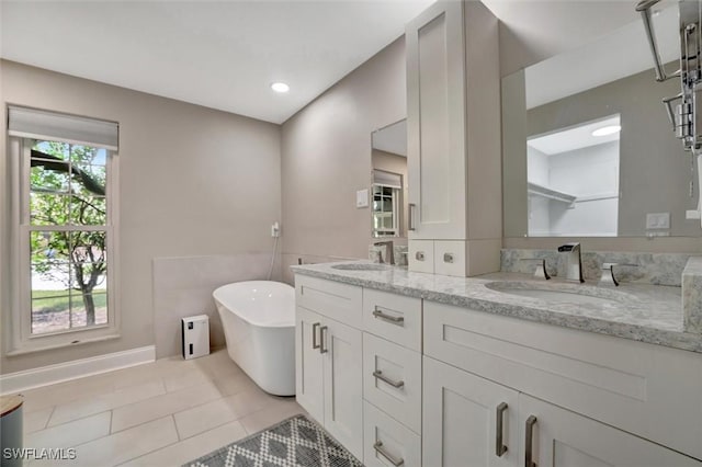 bathroom with tile patterned flooring, vanity, and a bathing tub