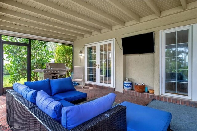 sunroom featuring beam ceiling and french doors