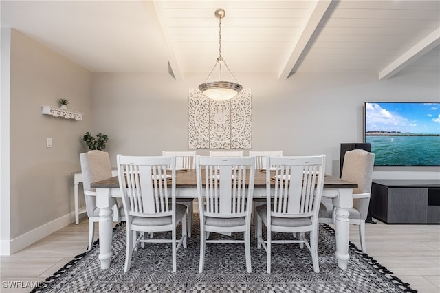 dining space with baseboards and beamed ceiling