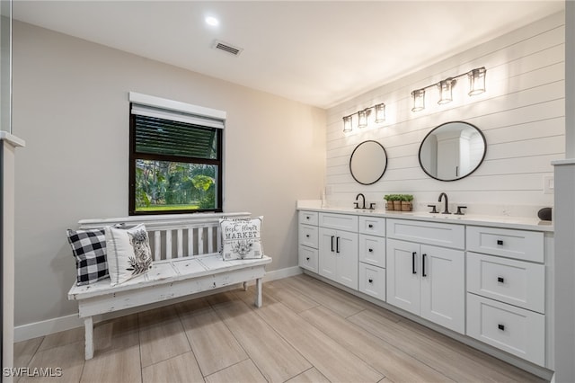 bathroom featuring double vanity, baseboards, visible vents, and a sink