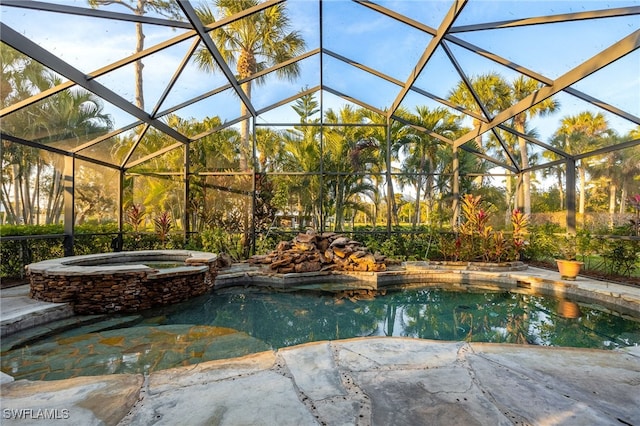 view of swimming pool with an in ground hot tub, glass enclosure, and a patio