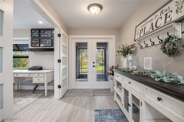 mudroom with french doors, a healthy amount of sunlight, and light hardwood / wood-style flooring