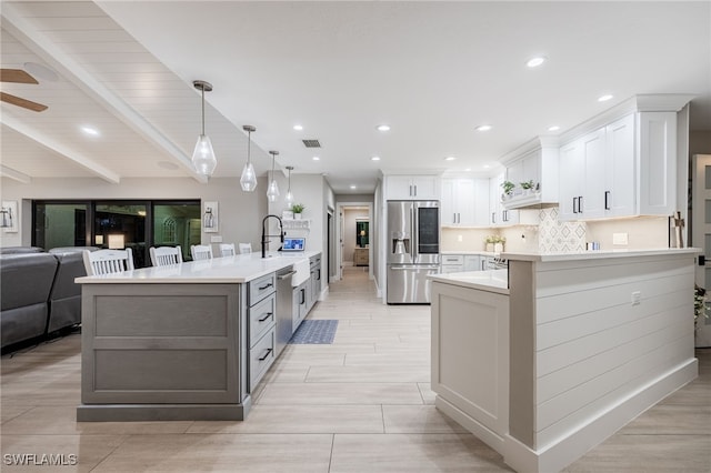 kitchen with white cabinetry, stainless steel appliances, a large island, and pendant lighting