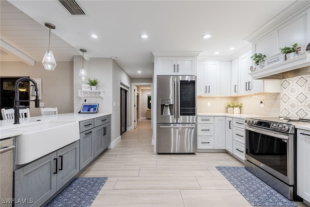 kitchen featuring white cabinets, appliances with stainless steel finishes, light countertops, and a sink