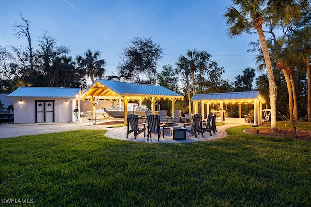 view of yard featuring a gazebo, an outdoor fire pit, a patio area, and an outbuilding